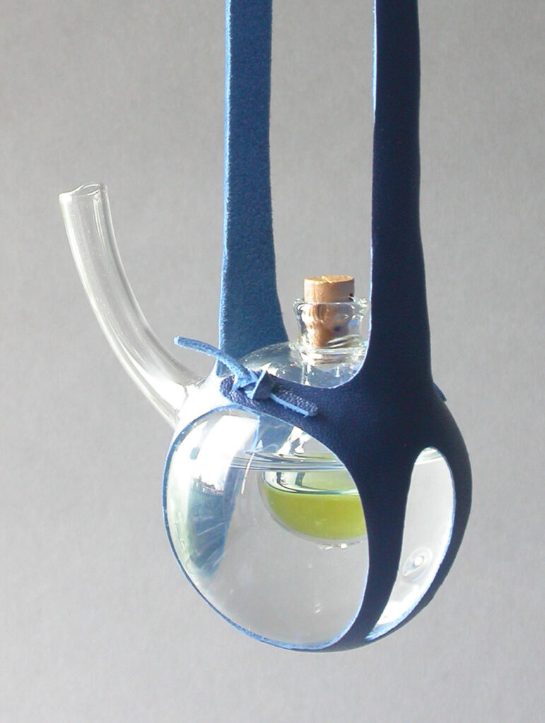foto van een halssieraad gemaakt van glas en leer.